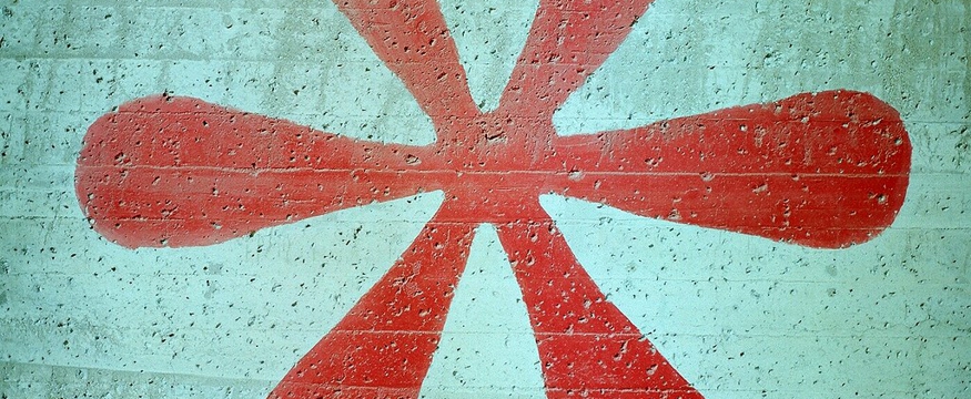 Ein roter Asterisk auf grauem Beton